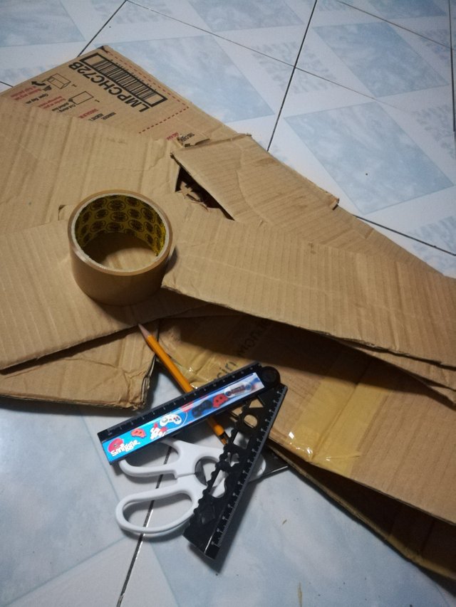 Cardboard, scissors, tape, ruler, and other supplies for Koko's homemade sorbetes cart